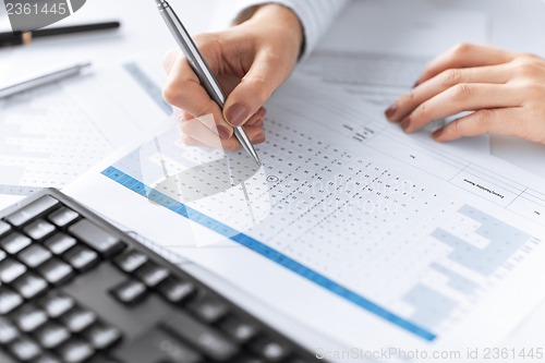 Image of woman hand writing on paper with numbers