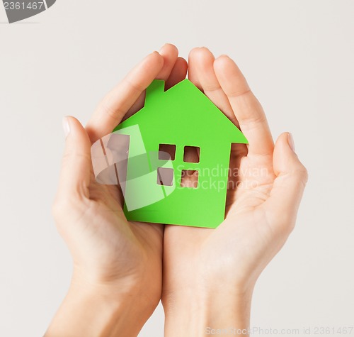 Image of hands holding green house