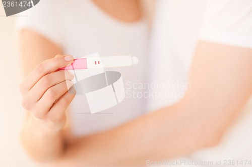 Image of woman and man hands with pregnancy test