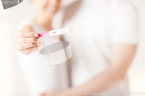 Image of woman and man hands with pregnancy test