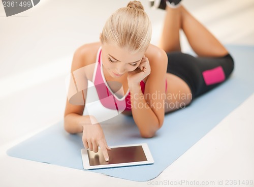 Image of woman lying on the floor with tablet pc