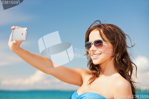 Image of woman in bikini with phone