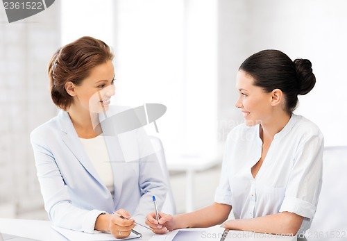 Image of two businesswomen having discussion in office