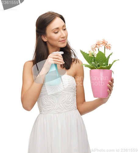 Image of woman holding pot with flower and spray bottle