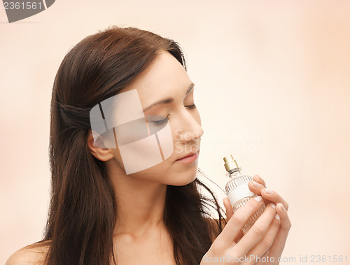 Image of woman smelling perfume