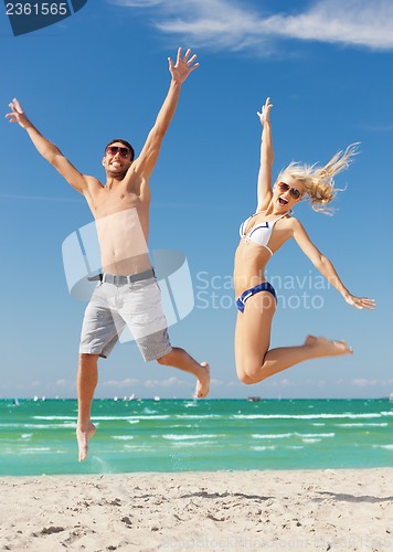 Image of couple jumping on the beach