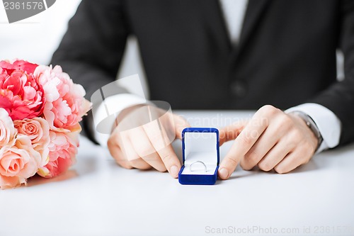 Image of man with gift box and wedding ring