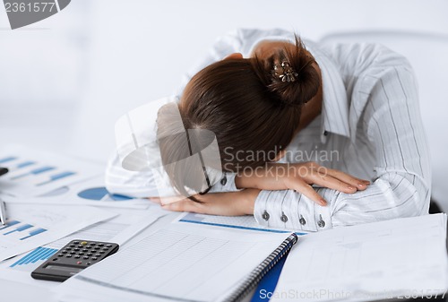 Image of tired woman sleeping at work