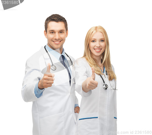 Image of young team of two doctors showing thumbs up