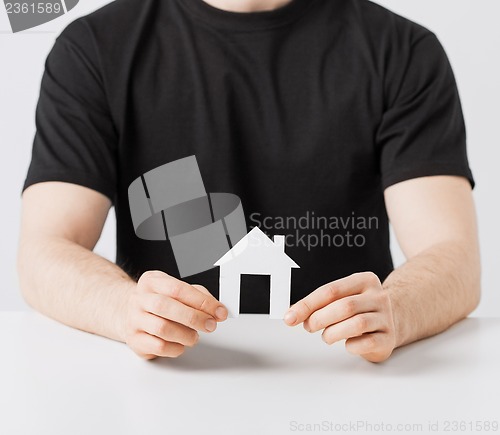 Image of man hands holding paper house