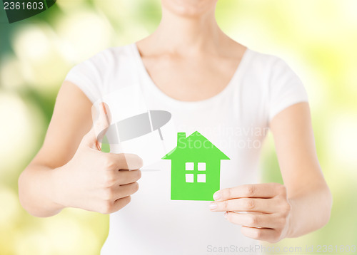 Image of woman hands holding green house