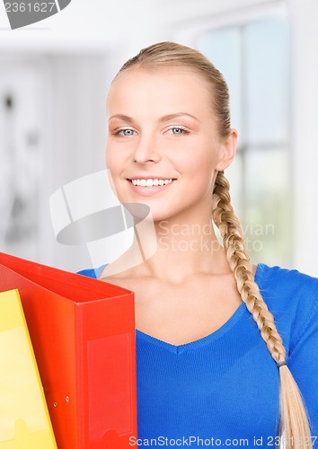 Image of young attractive businesswoman with folders