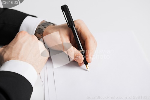 Image of businessman writing something on the paper