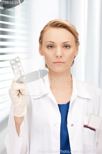 Image of attractive female doctor with pills