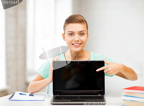 Image of smiling student girl with laptop at school