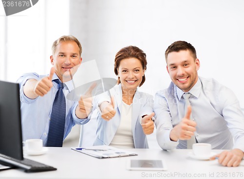 Image of business team showing thumbs up in office