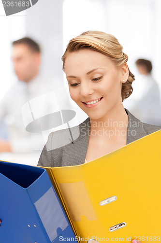 Image of young attractive businesswoman with folders