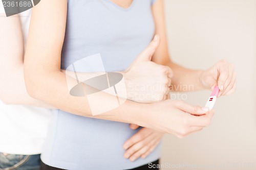 Image of woman and man hands with pregnancy test