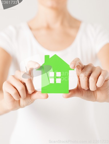 Image of woman hands holding green house