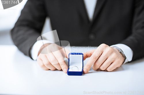 Image of man with gift box and wedding ring