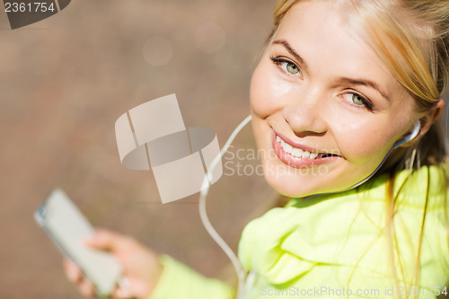 Image of woman listening to music outdoors