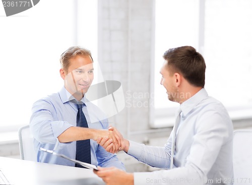 Image of businessmen shaking hands in office