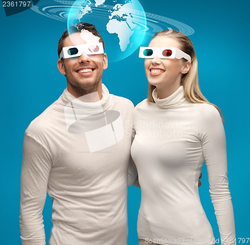 Image of woman and man in 3d glasses looking at globe model