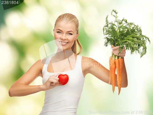Image of woman holding heart symbol and carrots