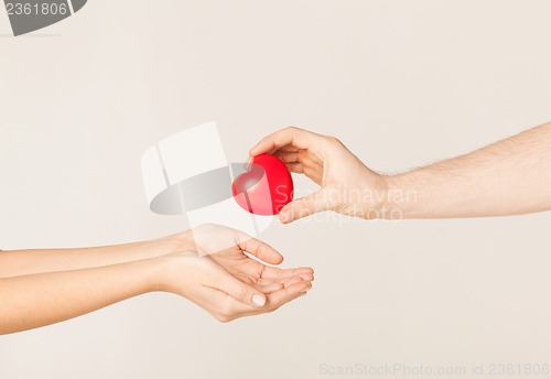 Image of woman and man hands with heart