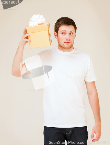 Image of man in white t-shirt with gift box