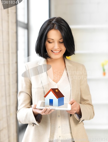 Image of woman holding tablet pc with house illustration