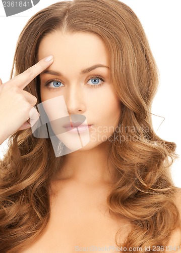 Image of beautiful woman pointing at her forehead