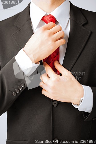 Image of man adjusting his tie