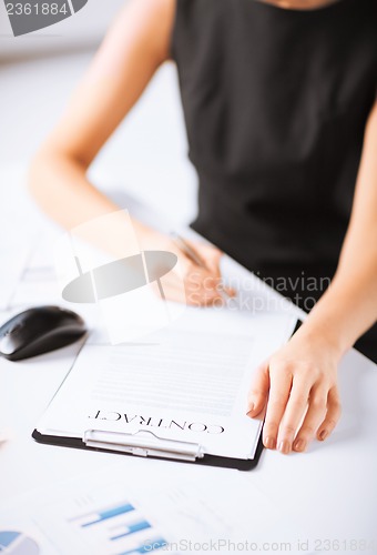 Image of woman hand signing contract paper