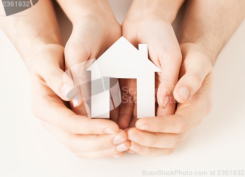 Image of woman and hands with paper house