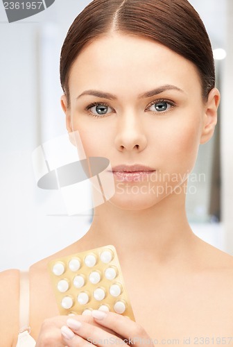 Image of young beautiful woman with pills