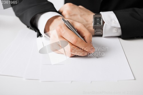 Image of businessman writing something on the paper