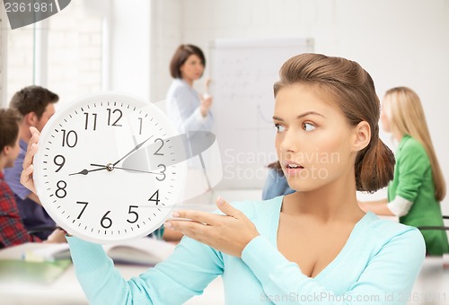 Image of girl holding big clock at school