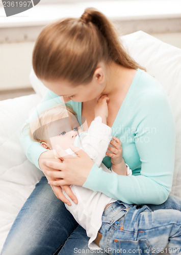 Image of mother and adorable baby with feeding-bottle