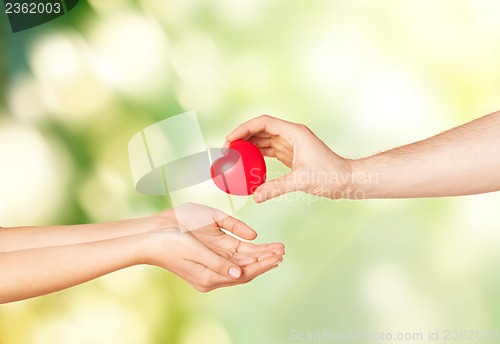 Image of woman and man hands with heart