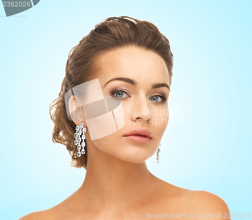 Image of woman wearing shiny diamond earrings