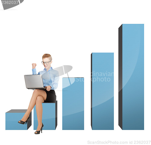 Image of businesswoman sitting on big 3d chart