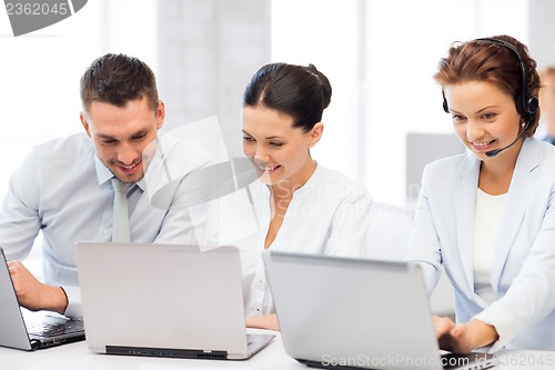 Image of group of people working with laptops in office