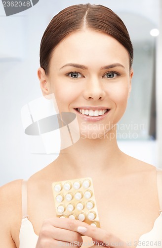 Image of young beautiful woman with pills