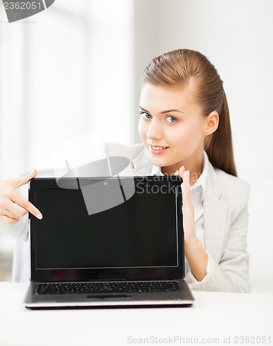 Image of businesswoman with laptop in office