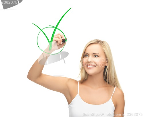 Image of woman in white shirt drawing green checkmark