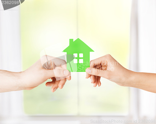 Image of couple hands holding green house