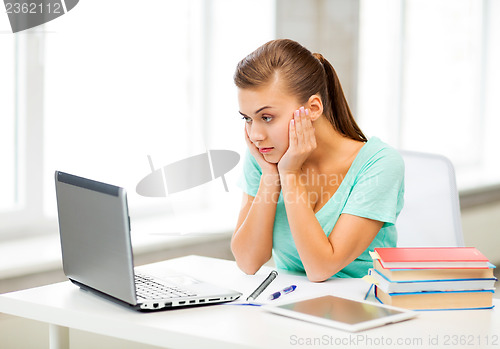 Image of stressed student with computer at home