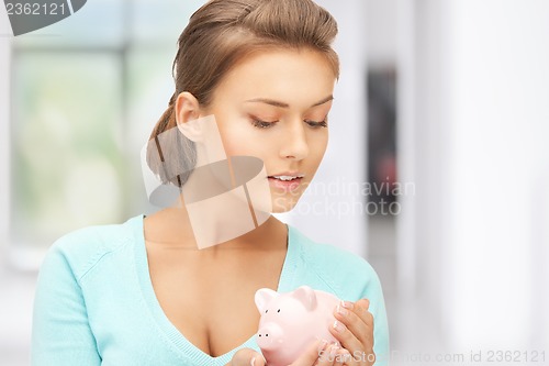 Image of lovely woman with piggy bank