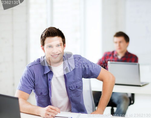 Image of smiling student with laptop at school